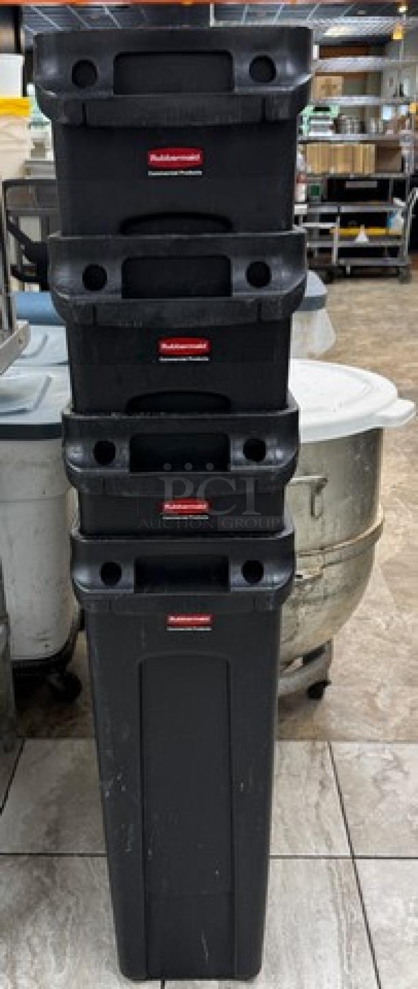 Stack of four Rubbermaid 23-gallon black containers, sturdy design, stackable with handles, in good condition.