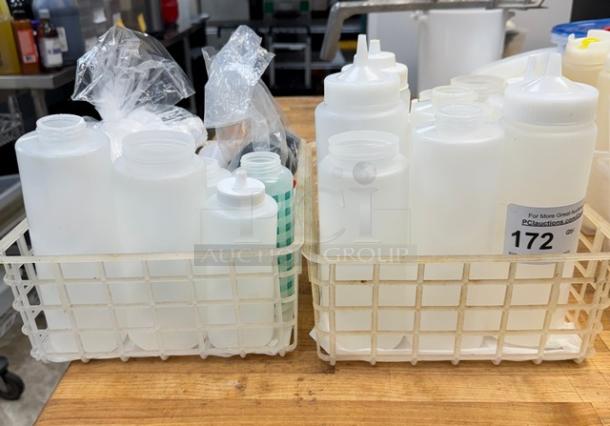 Assorted plastic condiment dispensers and lids in two basket containers on a wooden surface. Various sizes, new condition.