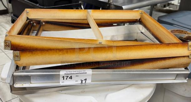 Full-size sheet pan extenders, stacked, showing slight wear. Includes auction label "174" indicating bid.