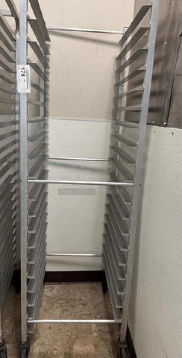 Rolling sheet pan rack with multiple shelves, aluminum construction, used condition, identification tag attached.