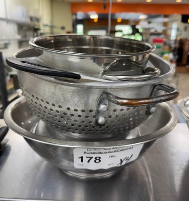 Three stacked colanders, two metal and one plastic, with visible label "178" for auction. In good used condition.