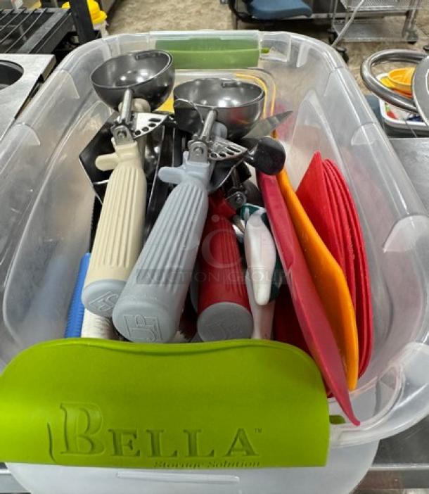 Assorted baking utensils in a clear container, brand "Bella," including scoops and spatulas with colorful handles.