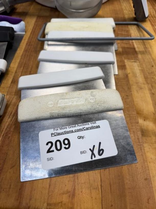 Set of 6 bench scrapers with white handles, metal blades, and auction label showing item 209, quantity 6.