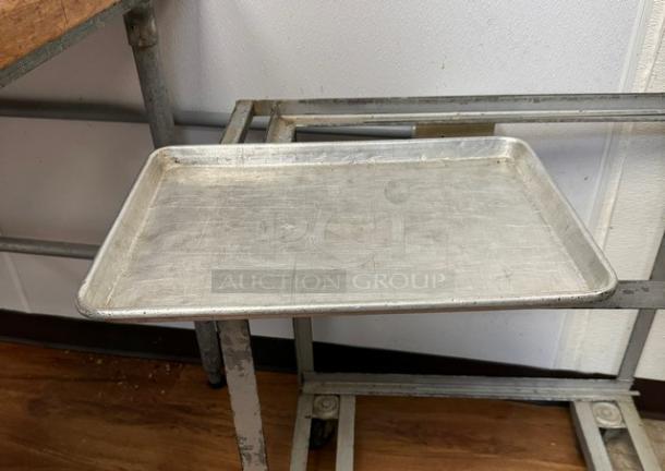 Half-size sheet pan, metal, slightly worn, rectangular, part of a 6-piece auction bid, ideal for baking or roasting.