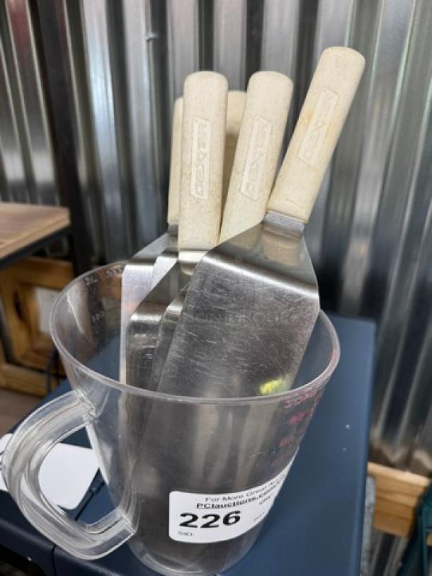 8-cup measuring cup holding six spatulas, metal blades with wooden handles, light wear. Marking indicates item number 226.