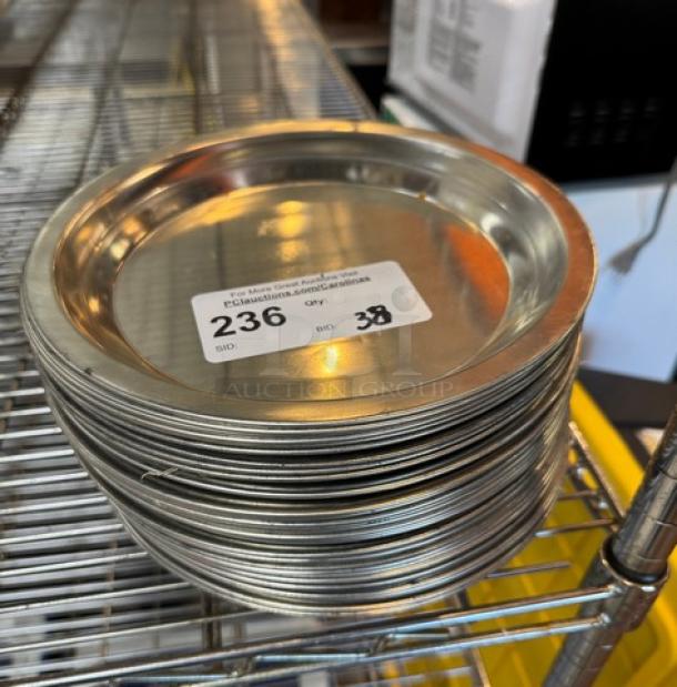Stack of 38 metal pie pans on shelf, excellent condition, showing auction tag with lot number 236.
