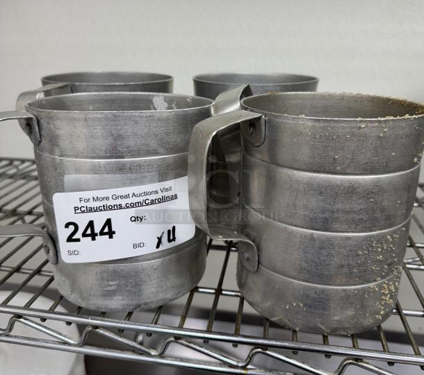 Metal 2 Qt. measuring cups, set of 4, used condition. Auction tag shows item number 244, with visible wear.