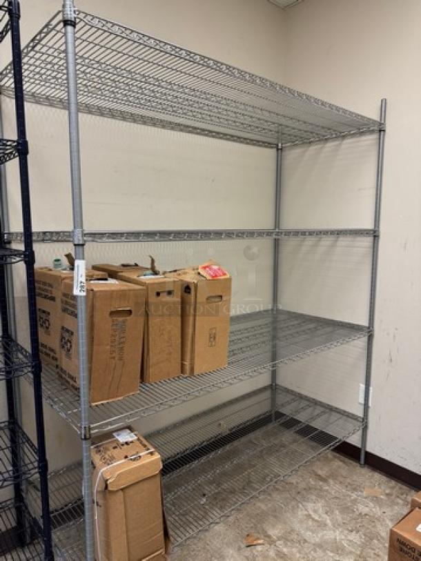 Wire rack with 4 shelves, steel construction, used, sturdy design. Contains cardboard boxes on shelves. Ideal for storage.
