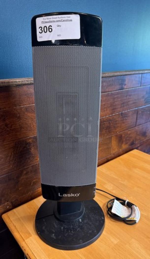 Lasko portable heater, black, sleek vertical design, with power cord. Item 306 tag displayed.