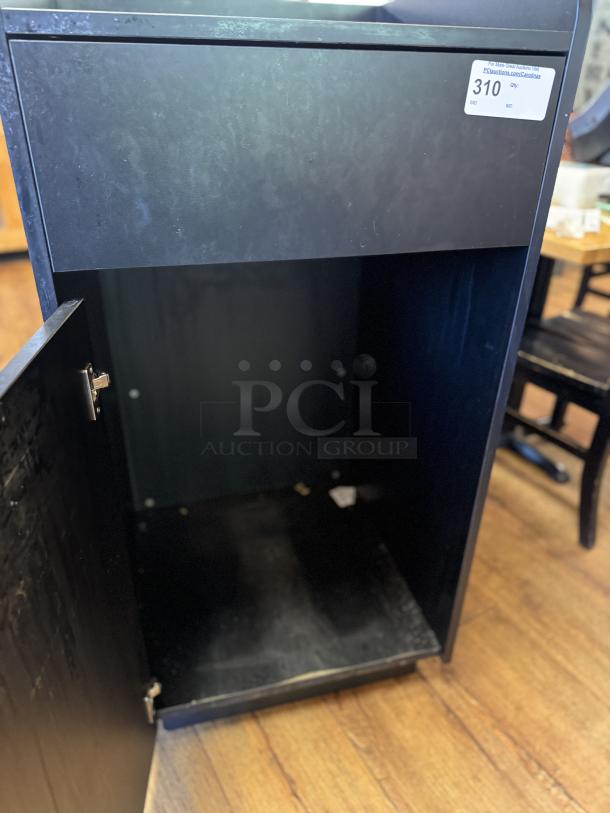 Black trash can bin with open front door, slight wear, visible auction tag with ID 310, suitable for indoor use.