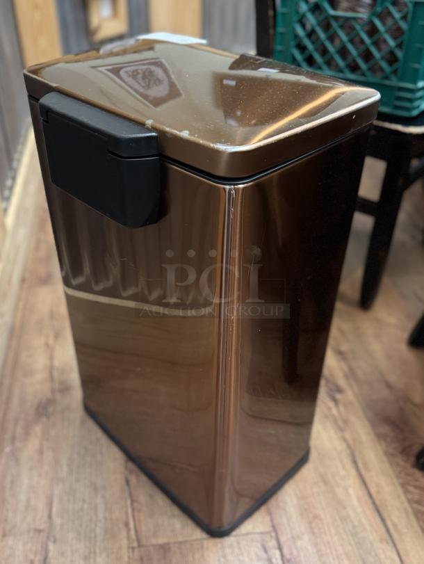 Tramontina trash can, metallic brown, rectangular shape, with black plastic lid, showing slight surface wear.
