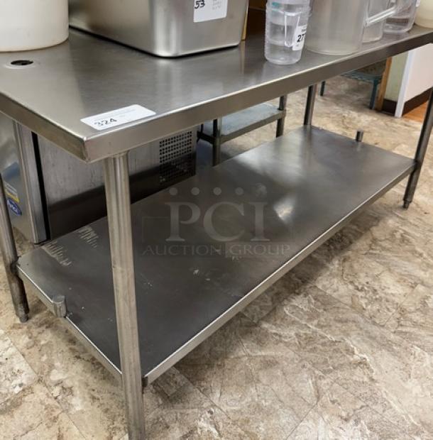 Stainless steel table with undershelf, suitable for kitchen use. Shows minor wear, sturdy construction, polished finish.
