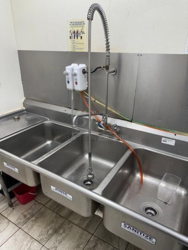 3 compartment sink with stainless steel construction, attached drainboards, and pre-rinse faucet; excellent condition.