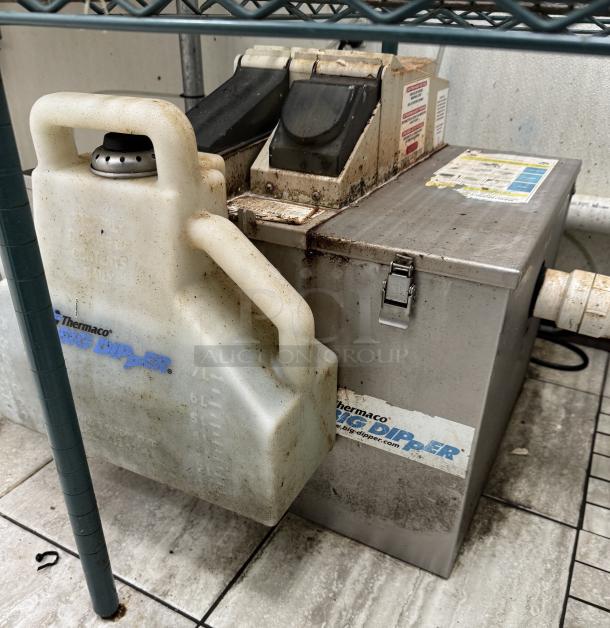 Thermaco Big Dipper grease trap, tested and working, stainless steel body, visible grime, brand and model labels, with plastic waste container.