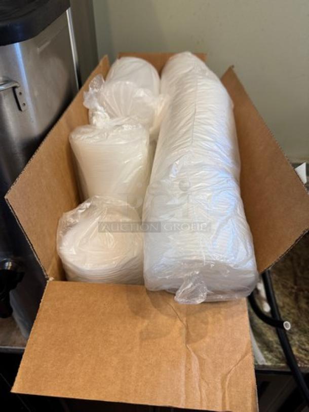 A box containing a case of new 4" plastic lids, individually wrapped, ready for distribution.