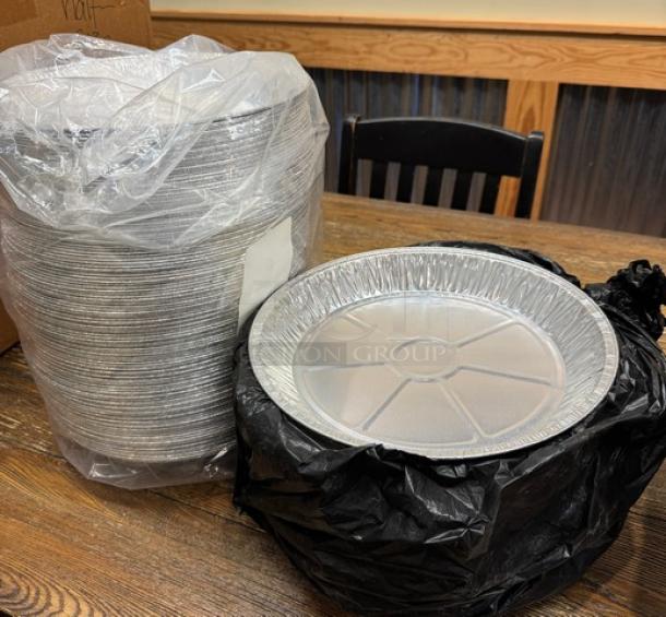 Disposable 9" round tin pans, stacked and wrapped, new condition, ideal for baking and food storage.