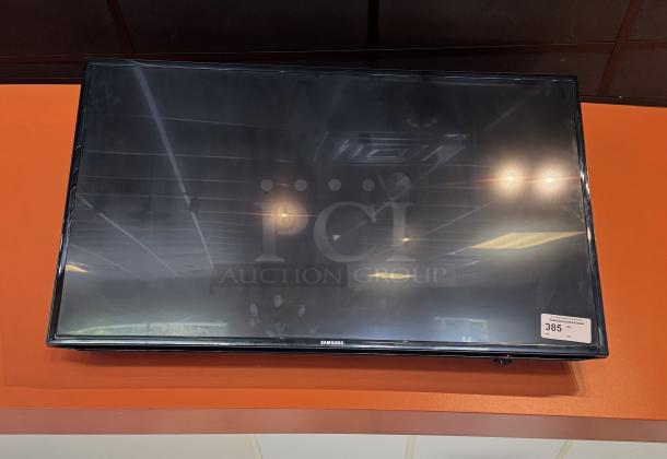 Samsung 52" TV with wall mount and remote, tested and working, model details visible on screen, good condition.