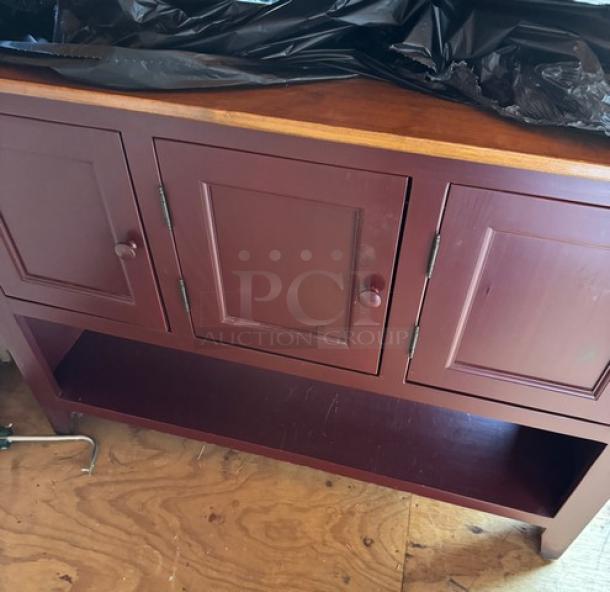 Amish made storage cabinet with three doors, rustic red finish, wooden top, open lower shelf, excellent condition.