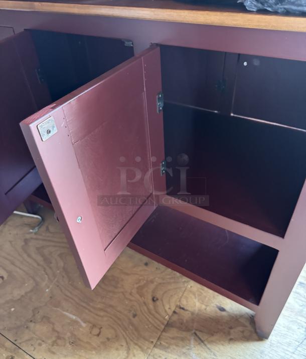 Amish-made storage cabinet with open double doors, showcasing spacious interior. Maroon finish, wood construction, excellent condition.