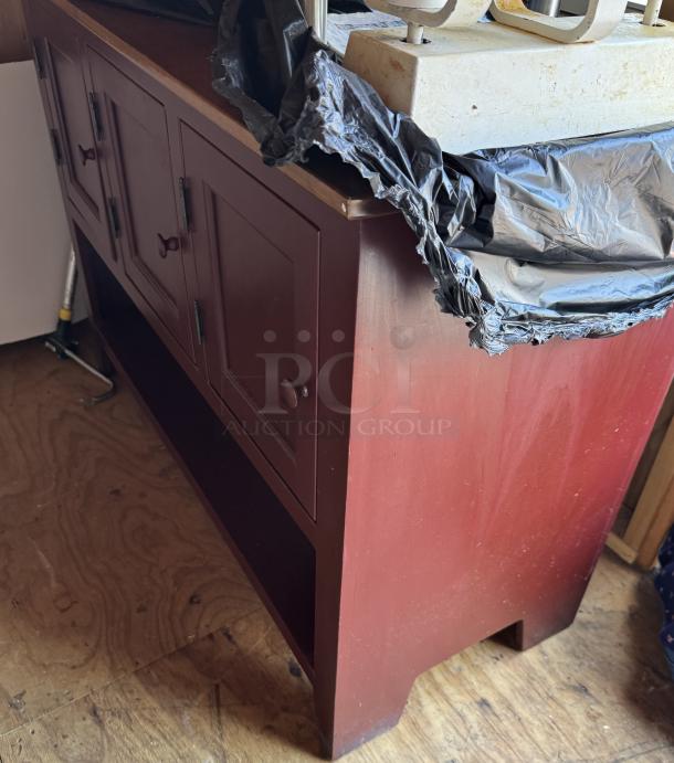 Amish made red storage cabinet with multiple doors, wooden knobs, slight wear, and a sturdy build suitable for home use.
