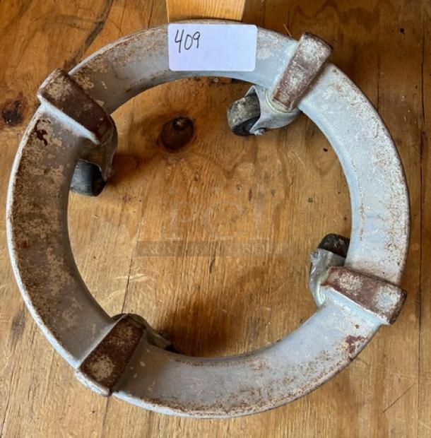 Cast iron mixing bowl dollie with four swiveling casters, rustic condition with surface rust, item tag "409" visible.