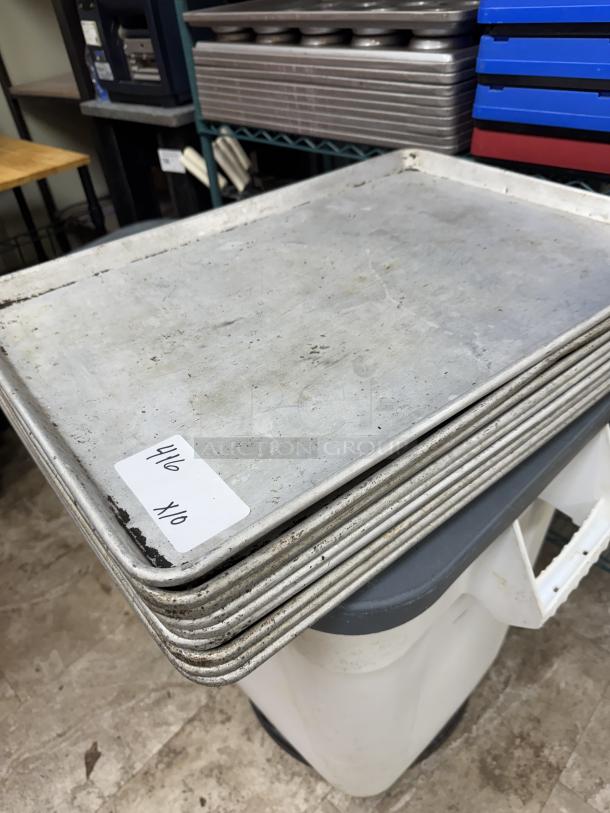 Stack of full-size sheet pans, used condition, metal, 10-count, labeled "4/6 X10" for auction bid.