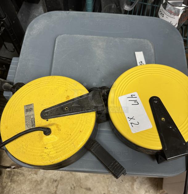 Two Bayco model 800 heavy-duty extension cord reels, yellow with black brackets, marked "417 x2," in used condition.