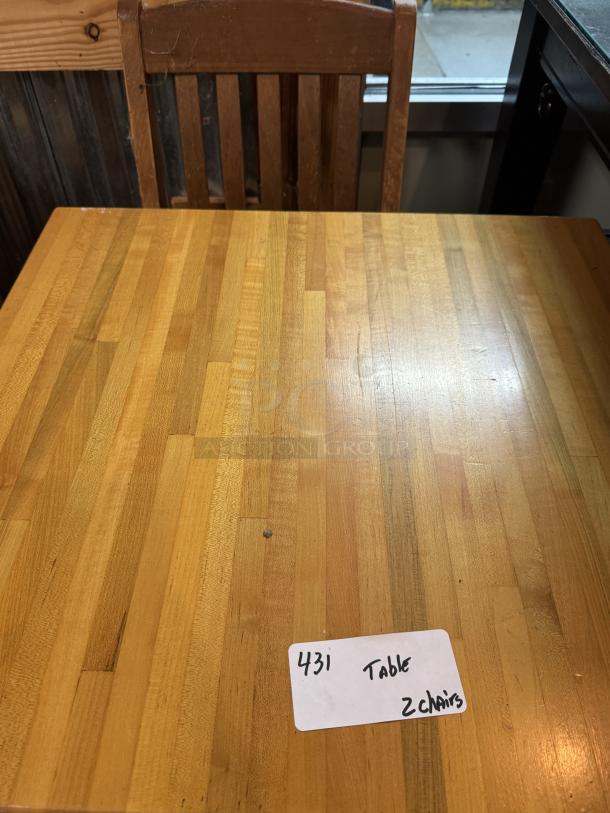 Wooden dining table with two matching chairs, light wood finish, minimal wear. Tag reads "431 Table 2 chairs."