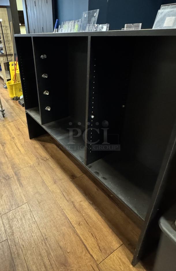 Black display case with adjustable shelves, four crystal knobs, and a worn finish. Ideal for retail or storage use.