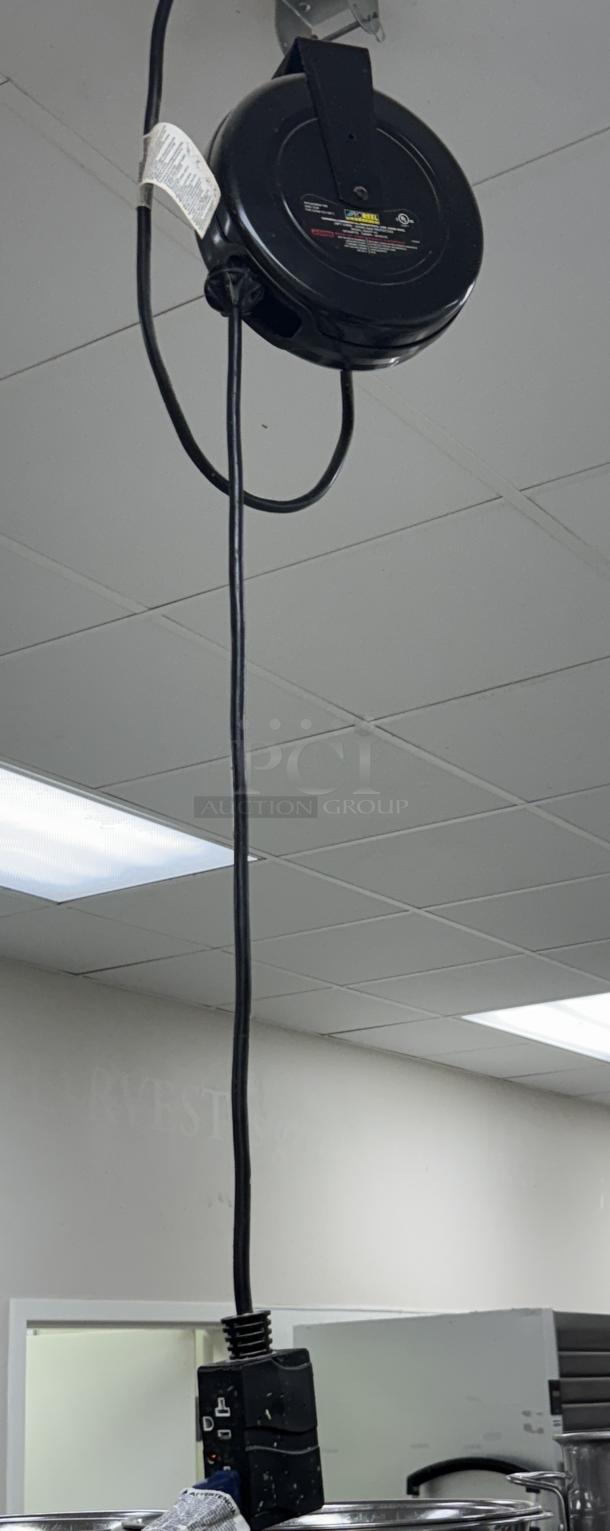 Pro Reel ceiling drop cord, black housing, retractable. Used condition, visible manufacturer label, mounted on ceiling.