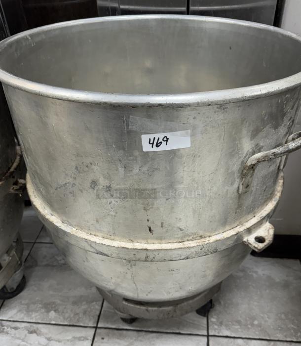 Alt text: Industrial 128 Qt. stainless steel mixing bowl with dollie, features handles and visible wear, labeled "469."
