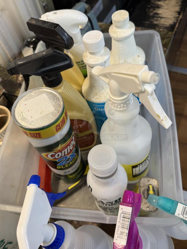 Assorted cleaning supplies with spray bottles in a plastic bin, featuring Comet 2x Bleach, various brands, and caps.
