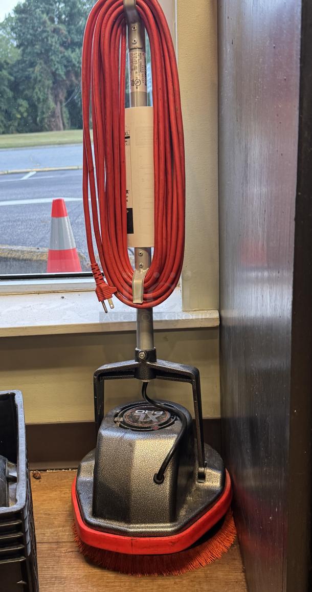 Oreck XL Pro Scrubbing Machine with red cord and brush attachment, tested and working condition, standing upright.