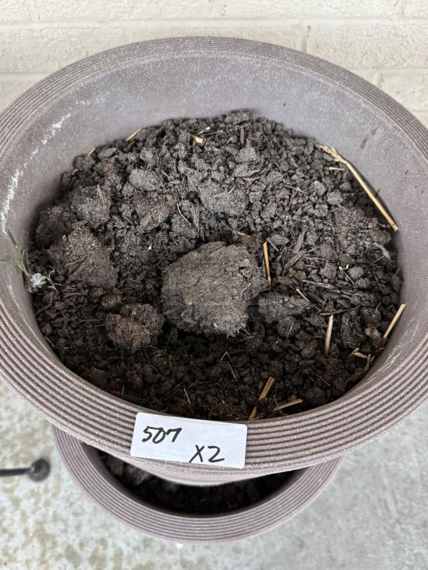 Two stacked brown flower pots filled with soil, visible label reads "507 X2." Ribbed design, suitable for outdoor use.