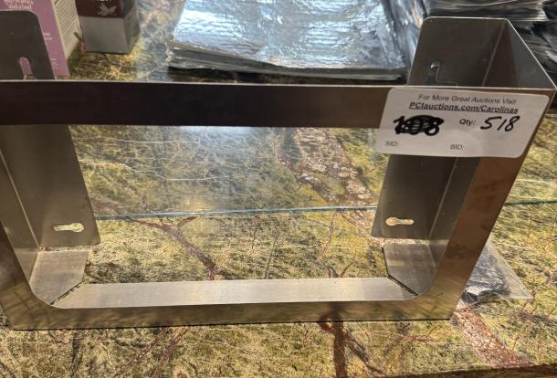 Stainless steel menu holder with mounting slots, new condition. Auction label shows item info and quantity 518.