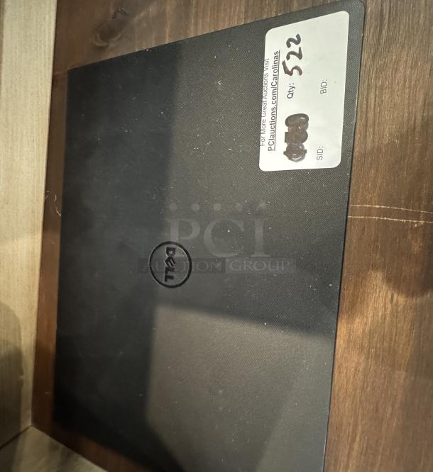 Dell Inspiron 15 3000 Series laptop, black, visible wear, Dell logo on lid, auction label indicating quantity and auction site URL.