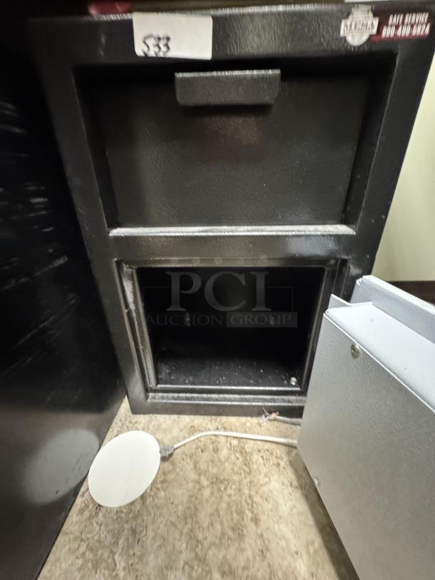 Black Mesa Safe with upper drop slot, open lower compartment, Model 533 tag, in good condition, suitable for secure storage.