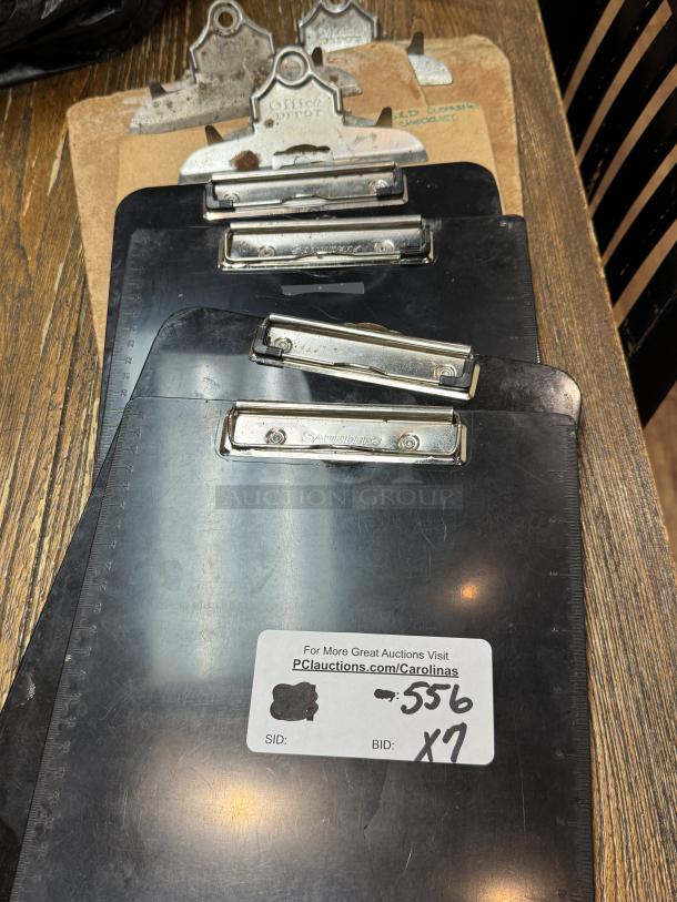 Assorted clipboards, various brands including Office Depot and Saunders, used condition, set of 7, auction ID label visible.