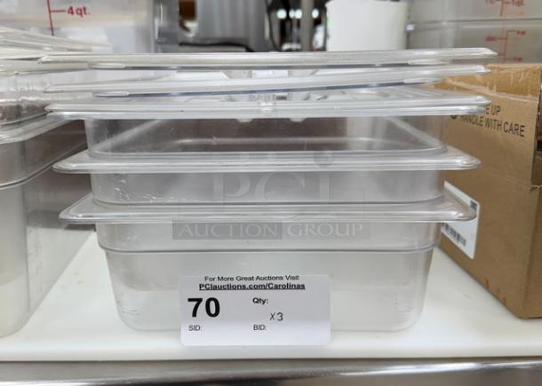 Stack of three Cambro plastic containers with lids, new condition, auction lot 70 sticker, stacked for display.