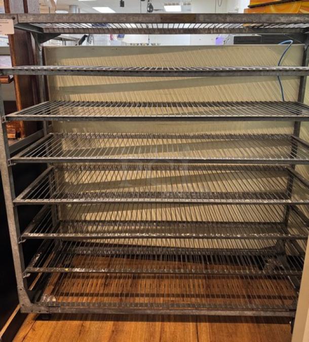 Metal rack with 8 wire shelves, silver finish, on casters for mobility. Ideal for storage. Good condition.