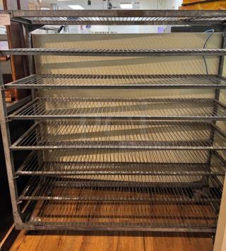 Metal rack with 8 wire shelves, silver finish, on casters for mobility. Ideal for storage. Good condition.
