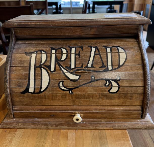 Wooden decorative bread box with roll-top lid and vintage "BREAD" lettering. Rustic finish, small knob, good condition.