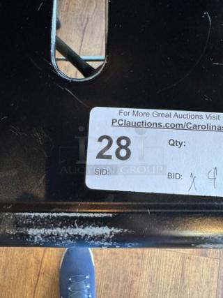 Black metal stool with auction label showing item number 28 and bid quantity x4; slight wear visible on surface.