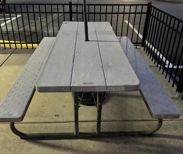 Lifetime Composite Picnic Table with wood-look finish, metal frame, excellent condition, visible brand markings on tabletop and benches.