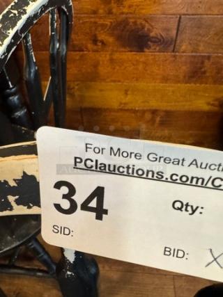 Four black dining chairs with a distressed finish, showing wear. Tag displays auction info: lot number 34.