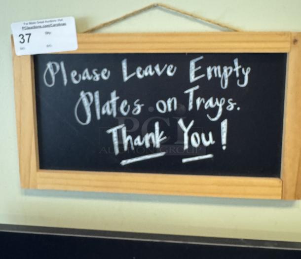 Wood-framed chalkboard sign with hanging rope, reads "Please Leave Empty Plates on Trays. Thank You!" Auction tag "37" attached.