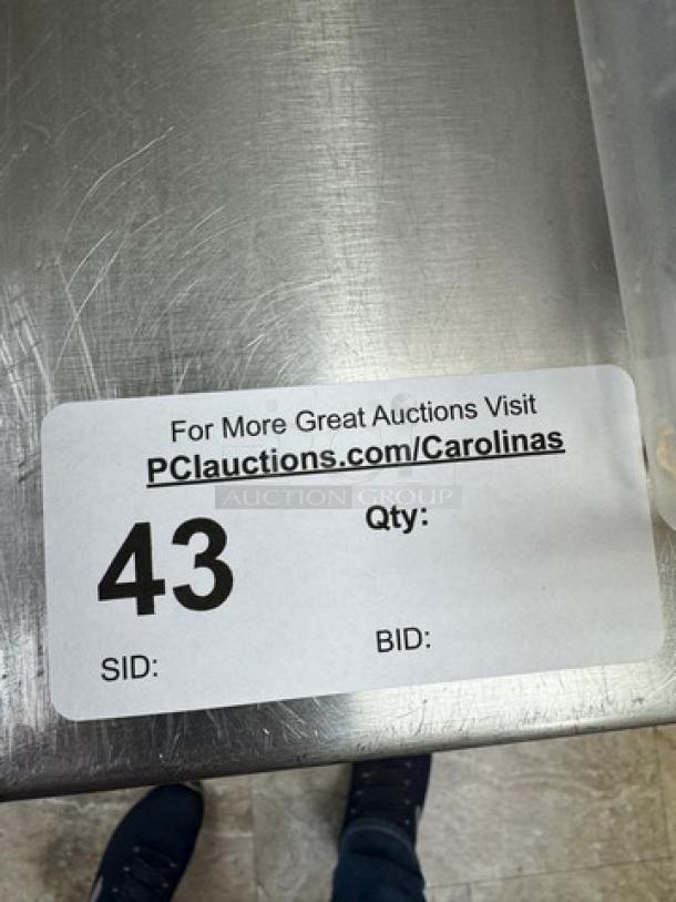 Stainless steel equipment stand with storage, auction tag "43", polished surface, suitable for industrial use.