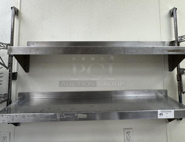Stainless steel shelving units, 2 pieces, wall-mounted, used condition, auction tag labeled "45" with "x2" marking.