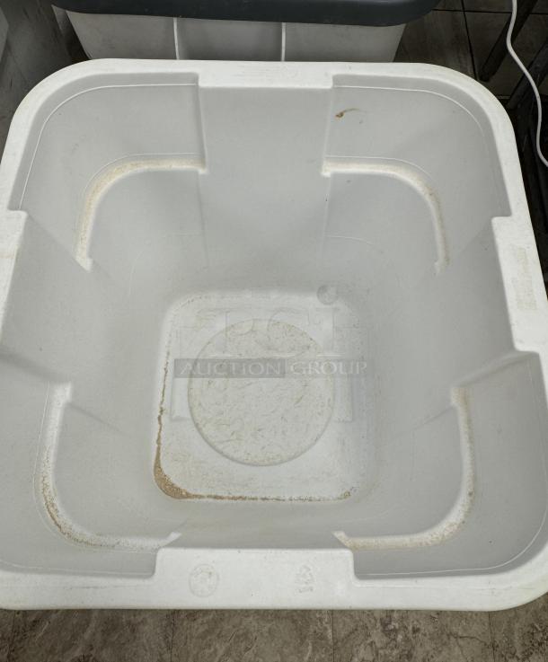 Rubbermaid 28 Gal. container with casters, used condition, visible interior marks, durable plastic, ideal for dry goods storage.