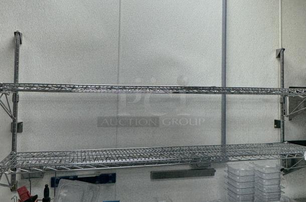 Stainless steel wire shelving with two adjustable shelves, in good condition, ideal for storage. Wall-mounted setup visible.